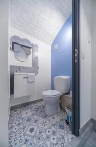 a bathroom with a white toilet and blue and white tiles at ⟬La Maisonnette de Séverine⟭ in Saint-Genès-Champanelle