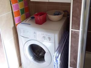 a washing machine with a bowl on top of it at White Ocean in Mawgan Porth