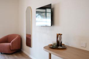 una stanza con tavolo, sedia e specchio di The Timothée Resort a Busselton