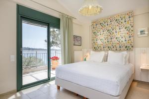 - une chambre avec un lit et une grande fenêtre dans l'établissement The Blue Olive villa Sithonia Halkidiki, à Vourvourou