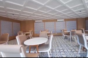 ダボリムにあるQuiet & Cozy Resort Style Fully Furnished 1-BHK Apartmentのテーブルと椅子、窓が備わる広い客室です。