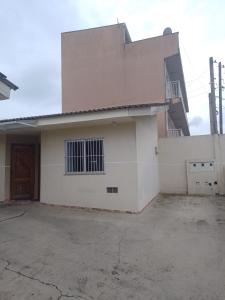uma grande casa branca com uma grande entrada em Residencial Vitor Studio 1 em São José dos Pinhais
