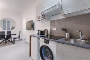 een keuken met een wastafel en een wasmachine bij Batignolles Lemercier Cosy Apartment 4P-1BR in Parijs