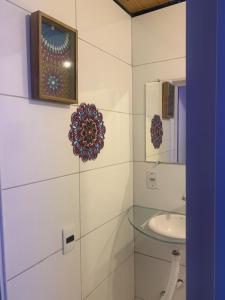 uma casa de banho com um lavatório de vidro e um espelho. em Toca da Suzara Suíte 1 até 4 pessoas Piscina Rio e Mar num só lugar em Florianópolis mais 45 fotografias