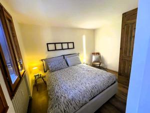 um quarto com uma cama, 2 candeeiros e uma janela em Le Bon Bon CIR-TORGNON-0017 em Torgnon