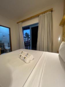 een wit bed met twee opgerolde handdoeken erop bij MAKTUB PREA HOSTEL in Prea