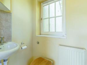 a bathroom with a sink and a window at Curlew Cottage in Hexham