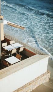 een tafel en stoelen naast de oceaan bij Palm Beach in Ajaccio