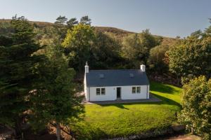 an aerial view of a white house on a lawn at Isle of Skye luxury cottage near Portree in Kensaleyre