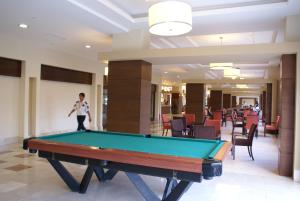 a man standing in a lobby with a pool table at Magic Sun Hotel in Beldibi