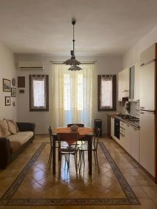 a living room with a table and chairs and a kitchen at Casa vacanza “O Bagghiu” in Bagheria