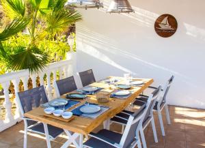 a wooden table and chairs on a patio with palm trees at Los-Barquitos in Torrox