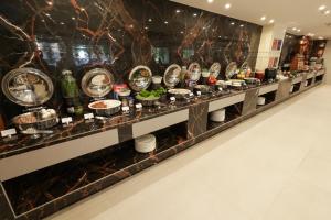 una linea a buffet con piatti e ciotole di cibo di Sobit Sarovar Portico a Palolem