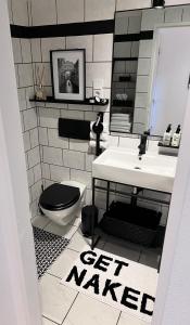 a bathroom with a toilet and a sink with a get wanted sign at V & S Apartments Since 2023 in Düsseldorf