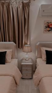 a bedroom with two beds and a lamp on a night stand at El mansour hotel apartmen 81 in Mansoura