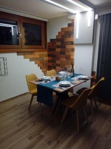 une salle à manger avec une table, des chaises et un escalier dans l'établissement Bilocale Funivie, à Breuil-Cervinia