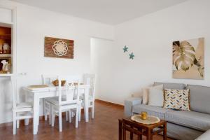 een woonkamer met een bank en een tafel bij Casa Famara in Famara