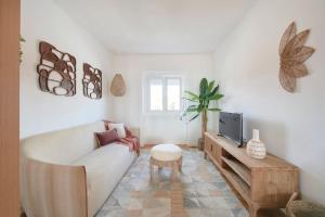 a living room with a white couch and a tv at Beato Tagus River View in Lisbon
