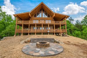 a log home with a fire pit in front of it at Big Bear Ridge Lodge - Breathtaking mountain views and private forest scenes in amazing large log cabin in Gatlinburg