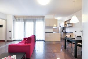 - un salon avec un canapé rouge et une table dans l'établissement Contempora Apartments - trilocale Largo Zanuso, à Milan