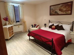 1 dormitorio con 1 cama grande con manta roja en Casa Serena, en Cave