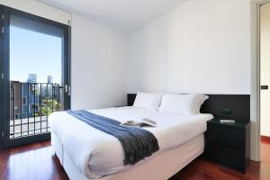 - une chambre avec un grand lit et une grande fenêtre dans l'établissement Contempora Apartments - trilocale Largo Zanuso, à Milan