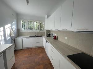 eine Küche mit weißen Schränken und Holzböden in der Unterkunft Beautifull Villa French Rivera in Spéracèdes