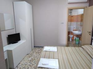 een kleine kamer met een bed en een televisie bij B&B Da Luca in Grottaminarda