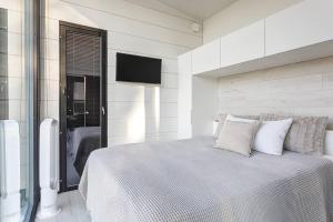 sypialnia z łóżkiem i telewizorem na ścianie w obiekcie Villa Noir Muurla - Premium - Lakefront - Stylish w mieście Salo
