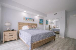a bedroom with a bed and a dresser and a mirror at Vistalmar Beach Resort in Deerfield Beach