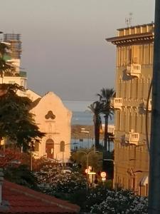 a view of a city with a building and palm trees at A due passi dal mare in Varazze