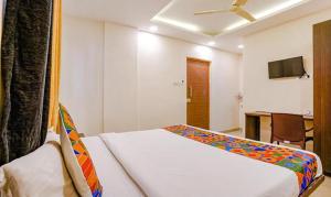 a bedroom with a bed and a desk and a tv at FabHotel Royal Inn NS in Pune