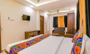 a hotel room with a bed and a television at FabHotel Royal Inn NS in Pune