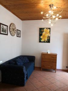 a living room with a couch and a clock on the wall at A due passi dal mare in Varazze