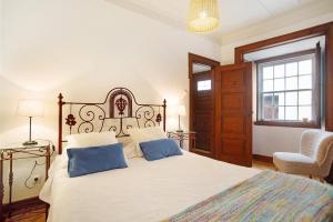 a bedroom with a large bed with two blue pillows at São Martinho All The Best in São Martinho do Porto