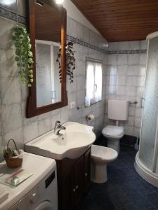 bagno con lavandino, servizi igienici e specchio di A due passi dal mare a Varazze