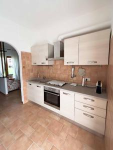 uma cozinha com armários brancos e piso em azulejo em Residenza Lucia em Campagnano di Roma