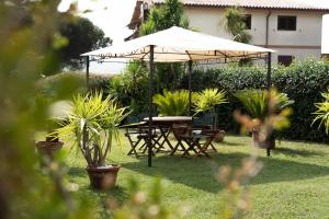 una mesa y sillas bajo una sombrilla en un patio en Residenza Lucia, en Campagnano di Roma