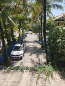 a car parked on the side of a road with palm trees at Pousada Bucaneiros in Arraial d'Ajuda