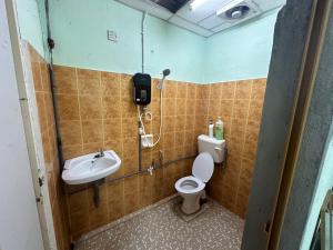 uma casa de banho com um chuveiro, um WC e um lavatório. em OYO 90881 Top Star Hotel em Kota Bharu