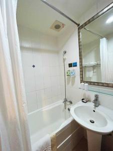 a bathroom with a sink and a tub and a mirror at 信然文旅-首學 寵物友善預訂前務必事先詢問 in Tainan