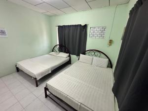 um quarto com duas camas e uma janela em OYO 90881 Top Star Hotel em Kota Bharu