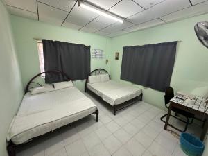 um quarto com duas camas e uma mesa em OYO 90881 Top Star Hotel em Kota Bharu