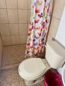 ein Badezimmer mit Toilette und Duschvorhang in der Unterkunft Hotel kale -iztac in Los Ayala + 10 Fotos
