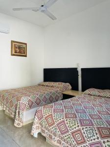 zwei Betten stehen nebeneinander in einem Schlafzimmer in der Unterkunft Hotel kale -iztac in Los Ayala