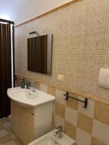 ein Badezimmer mit einem Waschbecken, einem WC und einem Spiegel in der Unterkunft Casa vacanza “O Bagghiu” in Bagheria