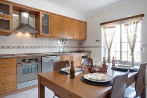 a kitchen with a wooden table and a dining room at A O - Ferrel House Casual in Ferrel