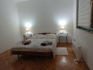 a bedroom with a bed and two lamps on two tables at Apartman 019 in Zaječar