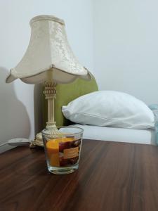 a lamp and a glass container of fruit on a table at Apartman 019 in Zaječar