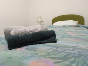 a bed with a black blanket on top of it at Apartman 019 in Zaječar